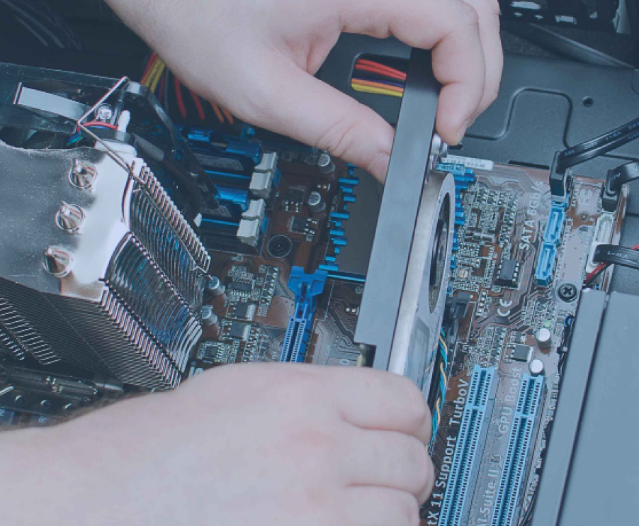 A technician carefully repairs a computer motherboard, focused on intricate components and connections.